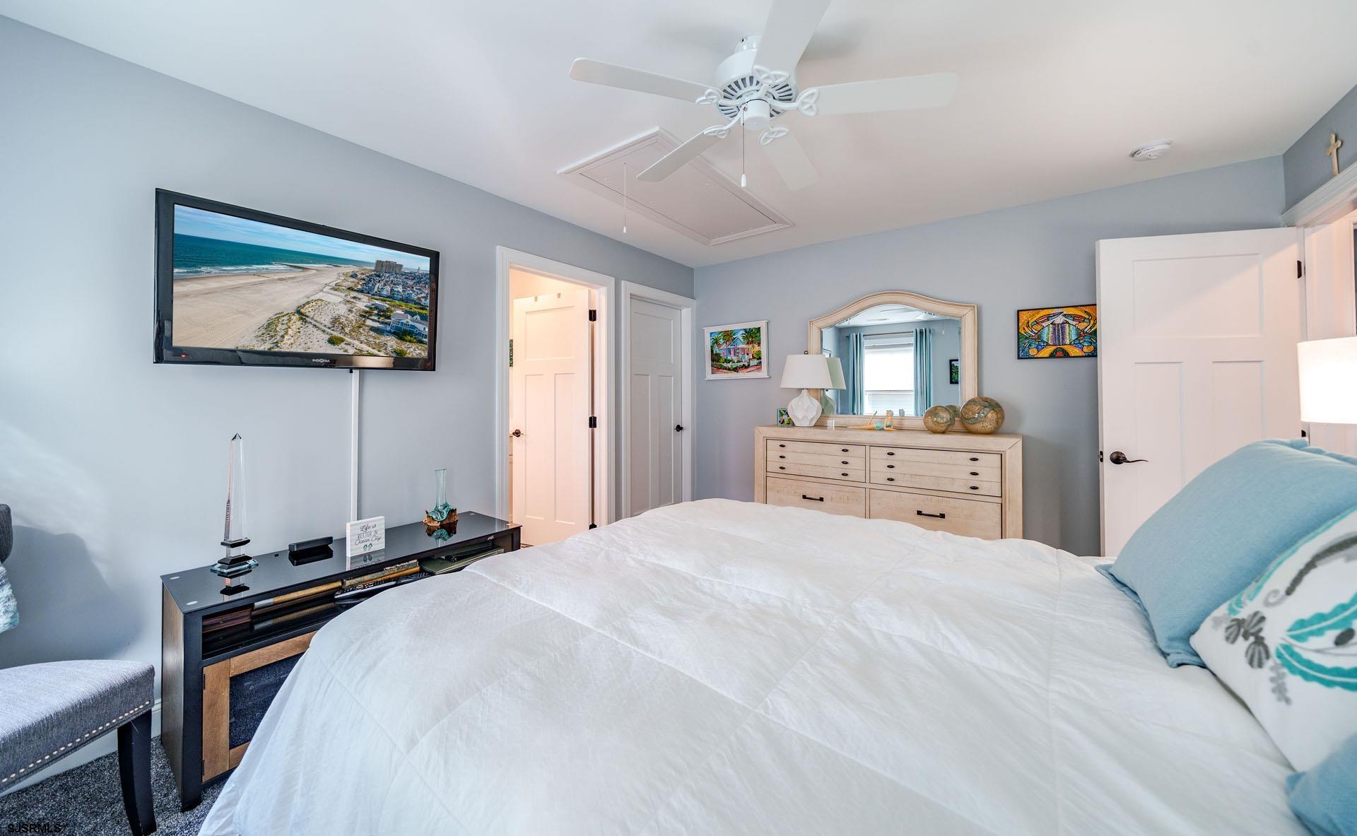 230 West Seaspray Road Ocean City, NJ 08226 - Photo 14 of 45 a bedroom with a bed and a chandelier