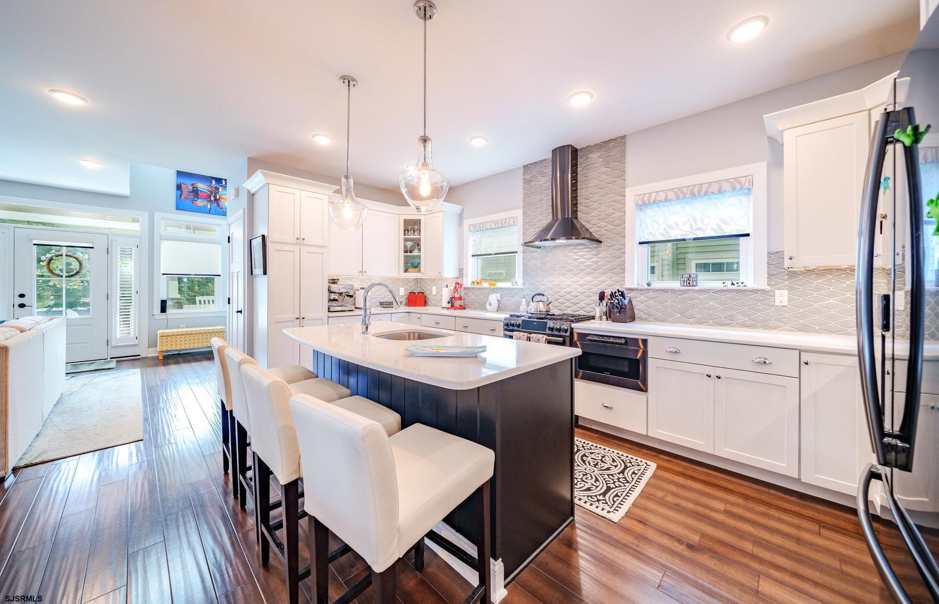 230 West Seaspray Road Ocean City, NJ 08226 - Photo 8 of 45 a kitchen with kitchen island granite countertop a sink a counter space dining table and stainless steel appliances