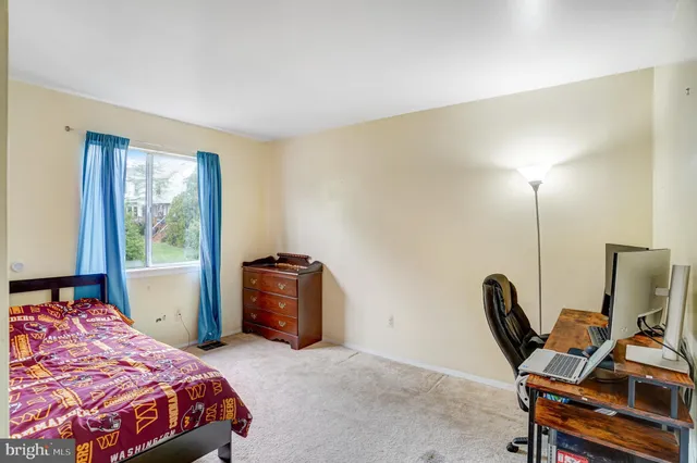 a bedroom with a bed a desk and chair