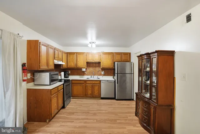 a kitchen with stainless steel appliances granite countertop a refrigerator stove and sink