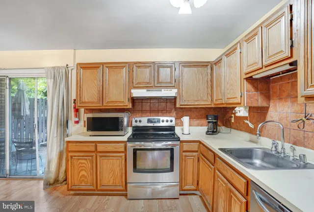 a kitchen with granite countertop a sink stove and cabinets