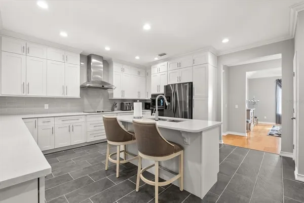 a kitchen with a sink dishwasher a stove and white cabinets with wooden floor