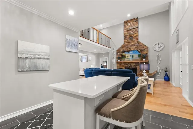 a living room with furniture kitchen view and a large window