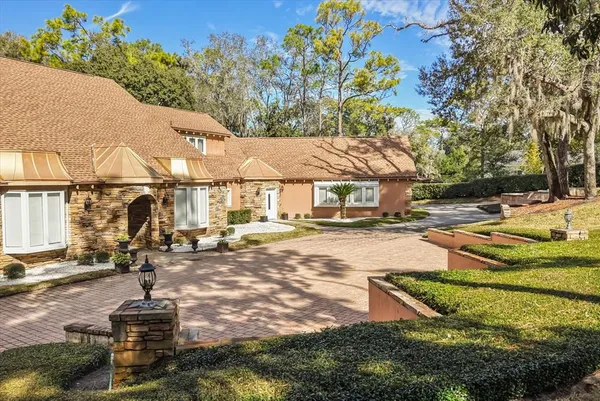 a dining room with wooden floor a chandelier a wooden table and chairs