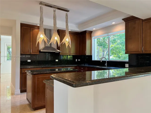 a kitchen with stainless steel appliances granite countertop a sink and a stove