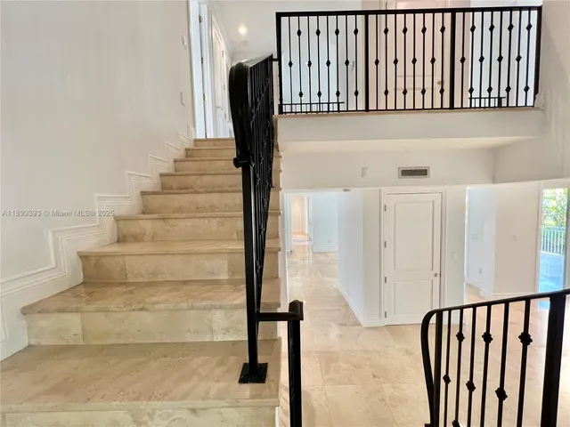 a view of staircase with railing and a rug