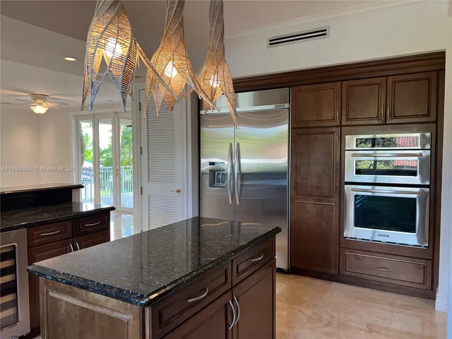 a kitchen with kitchen island granite countertop a stove and a sink