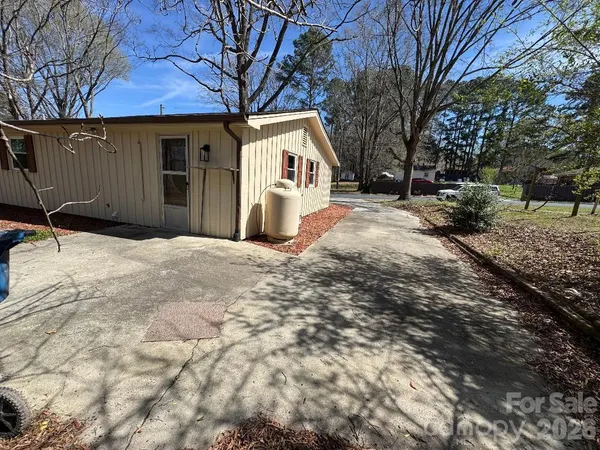 a white house that has a tree in front of it