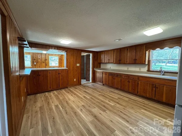 a large kitchen with wooden floors and wooden cabinets