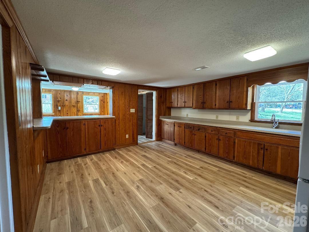 303 Green Street Biscoe, NC 27209 - Photo 3 of 15 a large kitchen with wooden floors and wooden cabinets