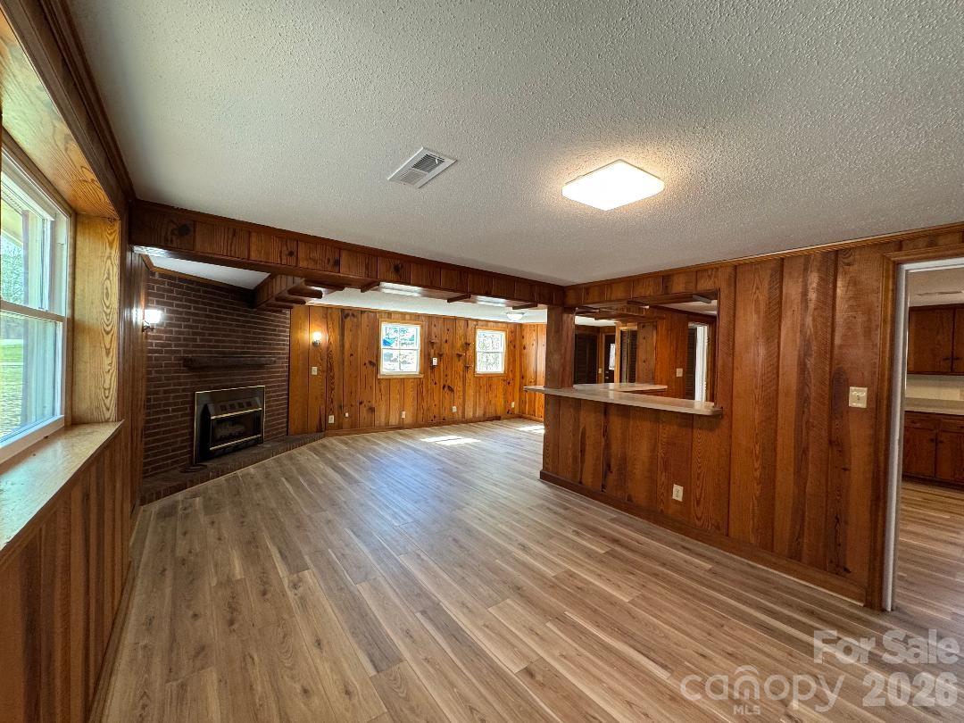 303 Green Street Biscoe, NC 27209 - Photo 4 of 15 en empty room with wooden floor fireplace and windows