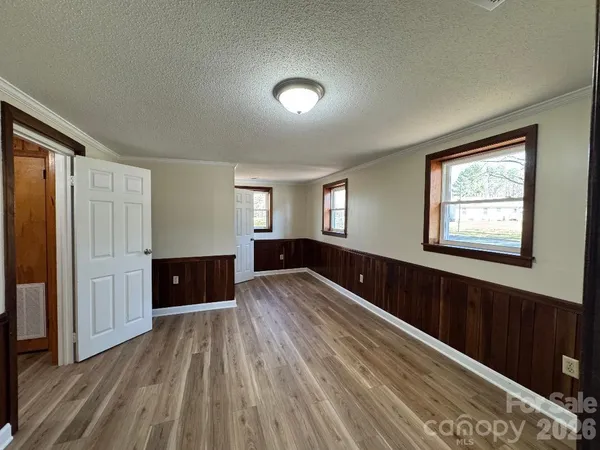 a spacious bedroom with a bed and a dresser