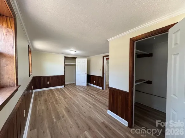 a view of empty room with wooden floor