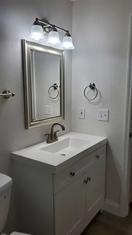 a bathroom with a toilet sink and mirror