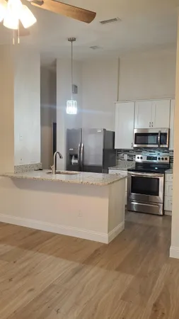 a large kitchen with kitchen island a sink stainless steel appliances and cabinets