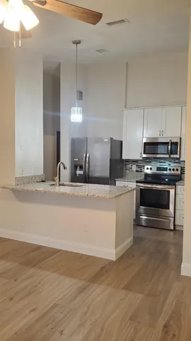 a large kitchen with kitchen island a sink stainless steel appliances and cabinets
