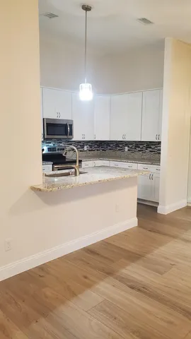 a kitchen with stainless steel appliances granite countertop a sink a stove and a refrigerator