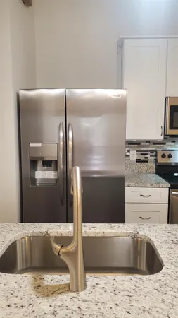 a bathroom with a granite countertop sink a stove and refrigerator
