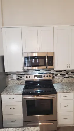 a stove top oven sitting inside of a kitchen