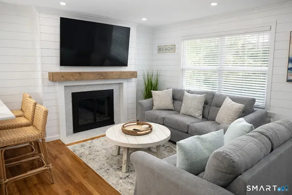 a living room with furniture a fireplace and flat screen tv