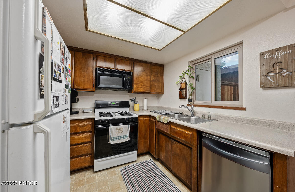 1210 East Walnut Avenue, Unit D Lompoc, CA 93436 - Photo 8 of 15 a kitchen with stainless steel appliances granite countertop a sink stove and microwave