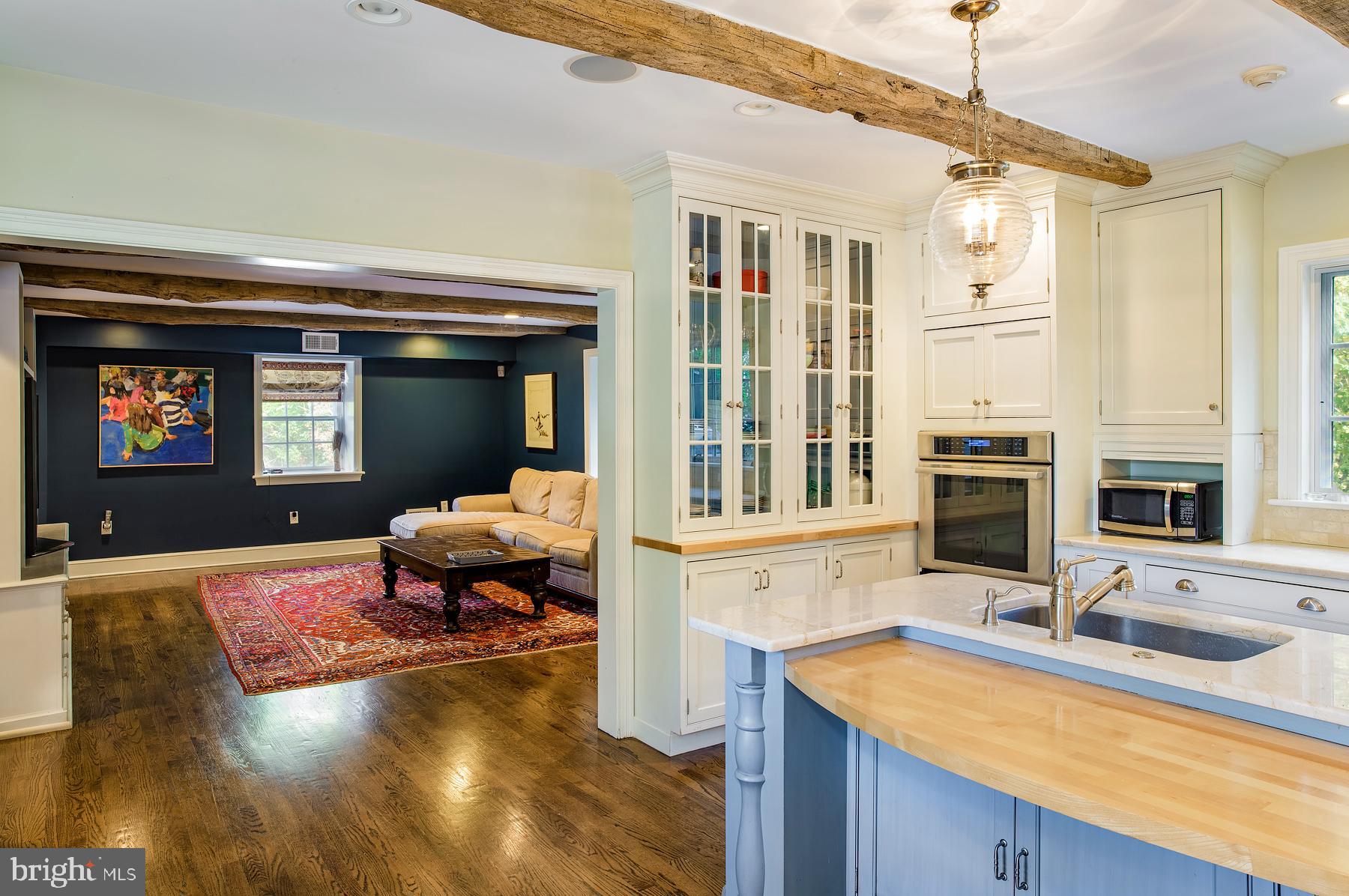 412 Righters Mill Road Narberth, PA 19072 - Photo 15 of 53 a living room with stainless steel appliances kitchen island granite countertop a sink dishwasher and a fireplace with wooden floor