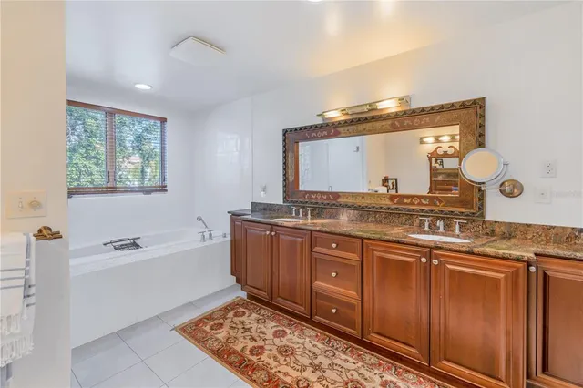 a bathroom with a granite countertop sink mirror and a bathtub