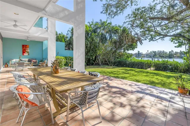 a view of a patio with table and chairs potted plants with large tree