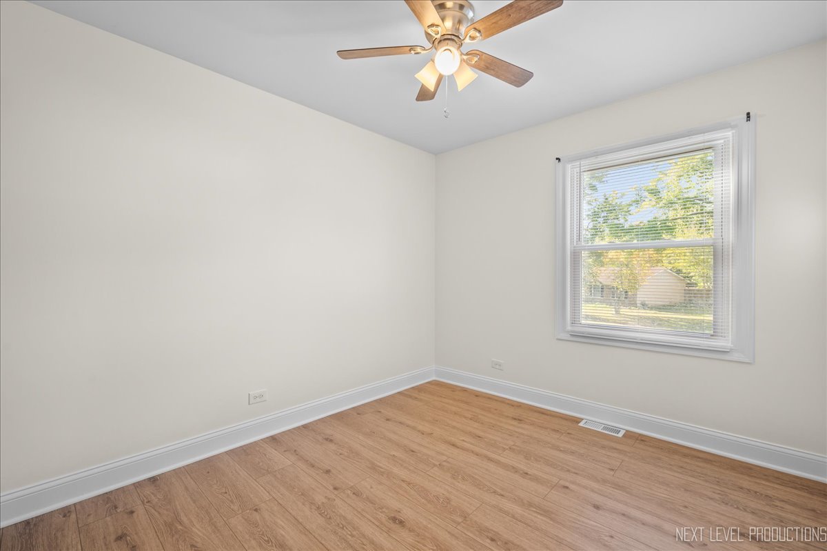 5628 Crestwood Road Matteson, IL 60443 - Photo 17 of 29 a view of an empty room with wooden floor and a window
