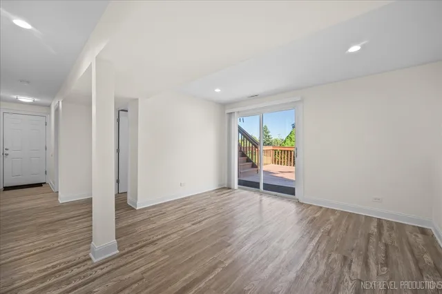 an empty room with wooden floor and window
