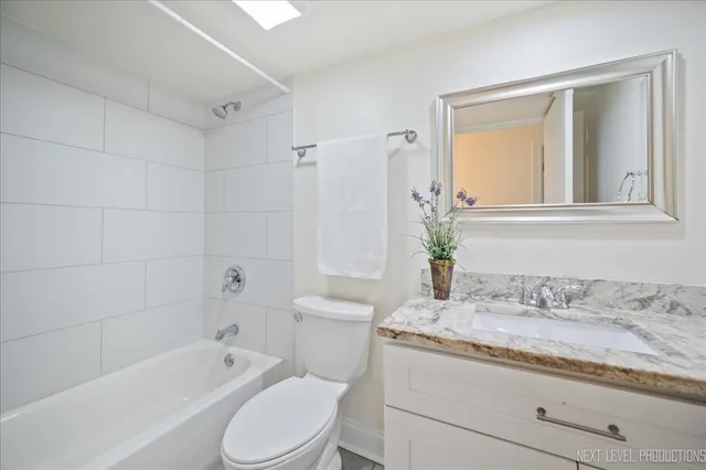 a bathroom with a granite countertop toilet a sink and bathtub