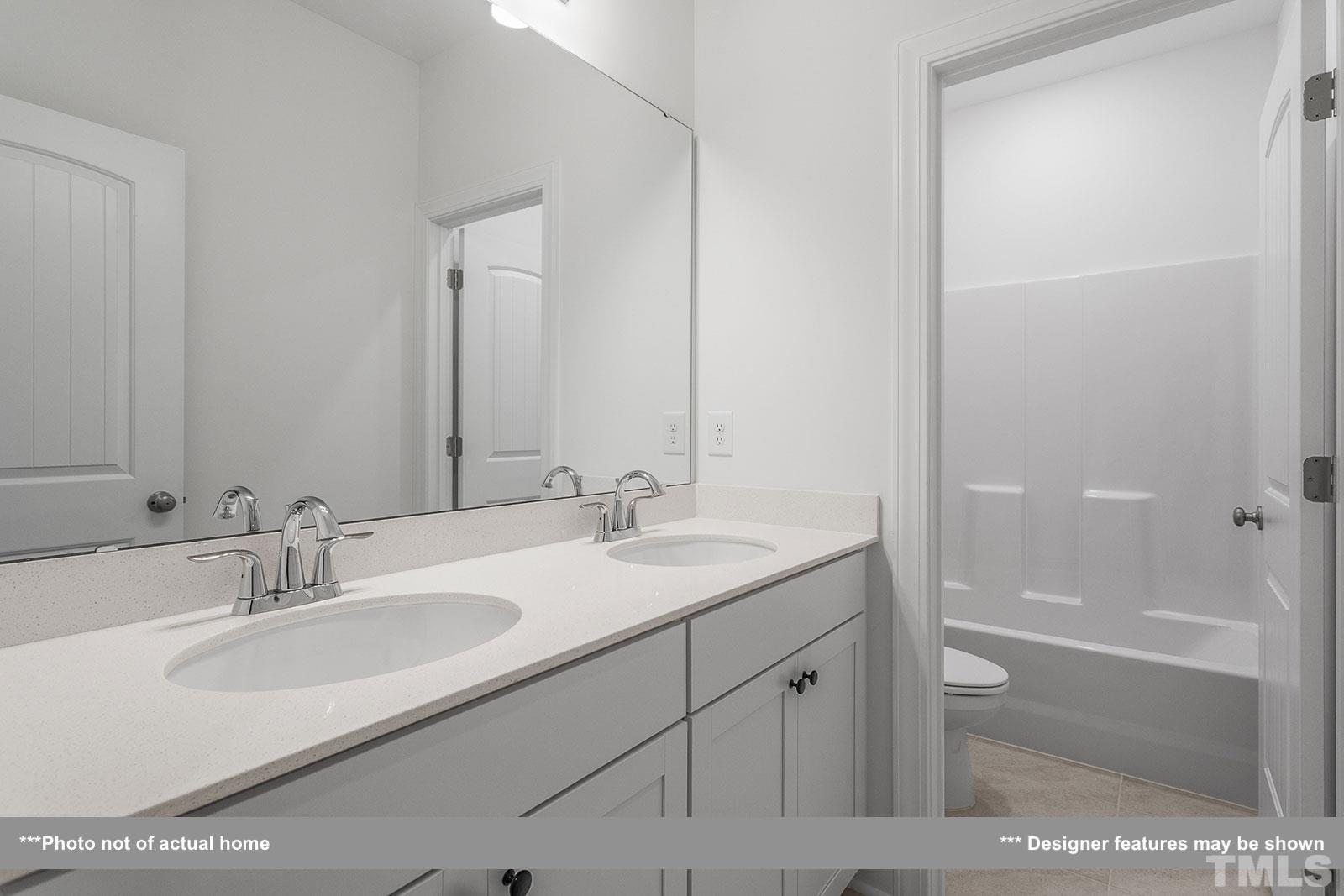 201 Dungannon Loop Clayton, NC 27520 - Photo 16 of 35 a bathroom with a sink and a mirror
