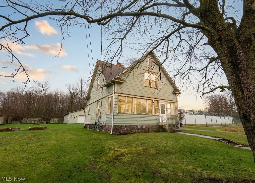 1195 South Johnson Road Sebring, OH 44672 - Photo 1 of 34 Property exterior at dusk featuring a chimney and a garage