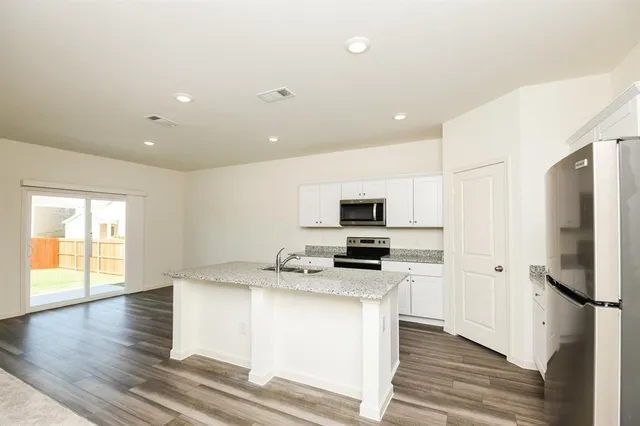 a kitchen with stainless steel appliances a refrigerator stove microwave and sink