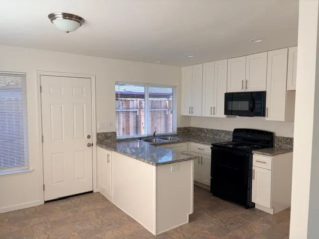 a kitchen with granite countertop a stove and a sink