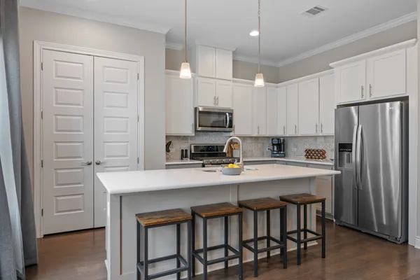 a kitchen with stainless steel appliances granite countertop a sink stove and refrigerator