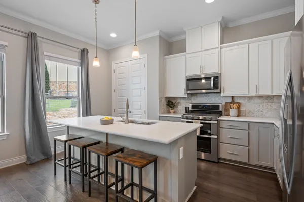 a large kitchen with kitchen island a sink table and chairs