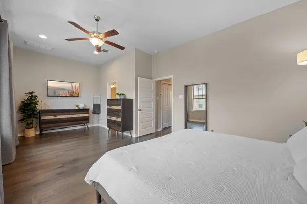 a spacious en suite bathroom with a granite countertop sink a light fixture and a mirror