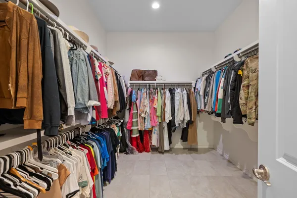 a view of walk in closet with clothes and shoes
