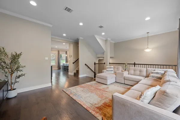a living room with furniture and a wooden floor