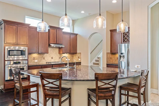 a kitchen with cabinets a center island and a chandelier