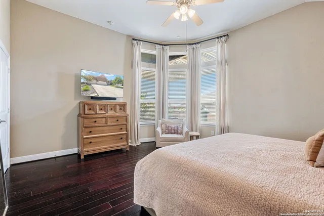 a spacious bedroom with a bed and wooden floor