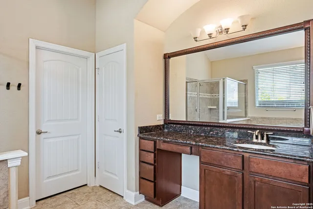 a bathroom with a granite countertop sink and a mirror