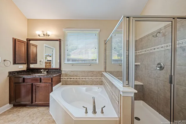 a bathroom with a bathtub a sink a vanity and a shower