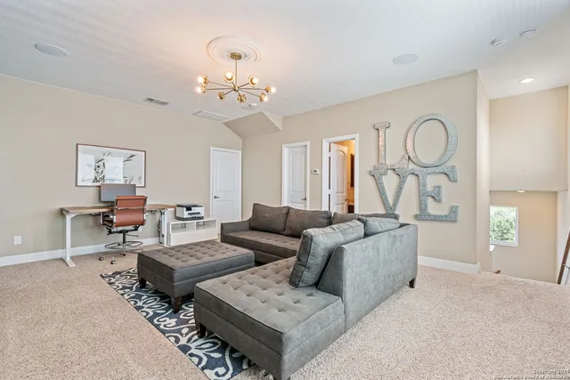 a living room with furniture chandelier and a mirror
