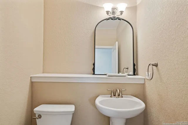 a bathroom with a sink a toilet and a mirror