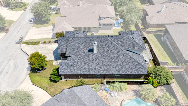 an aerial view of a house with a garden and large trees