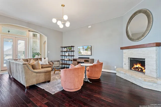 a living room with furniture a fireplace and a large mirror