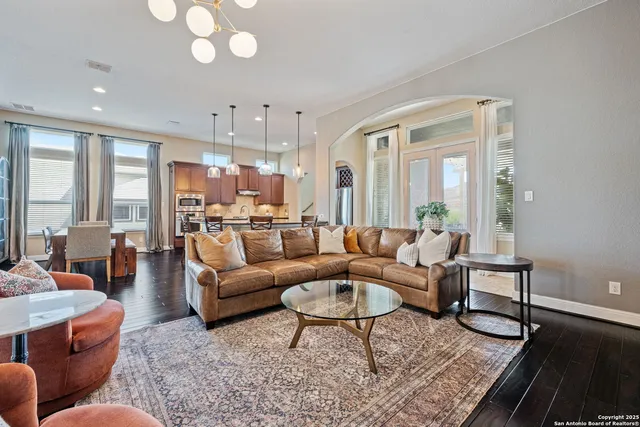 a living room with furniture wooden floor and a large window