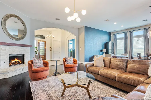 a living room with furniture a fireplace and a large window